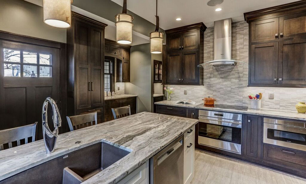 Kitchen remodel in the Twin Cities completed by Titus Contracting includes dark wood cabinets, stainless steel appliances and granite counter tops and a large kitchen island with seating.