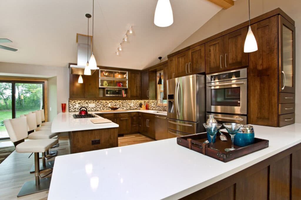 a kitchen with dark wood cabinets, a deluxe island and silver appliances