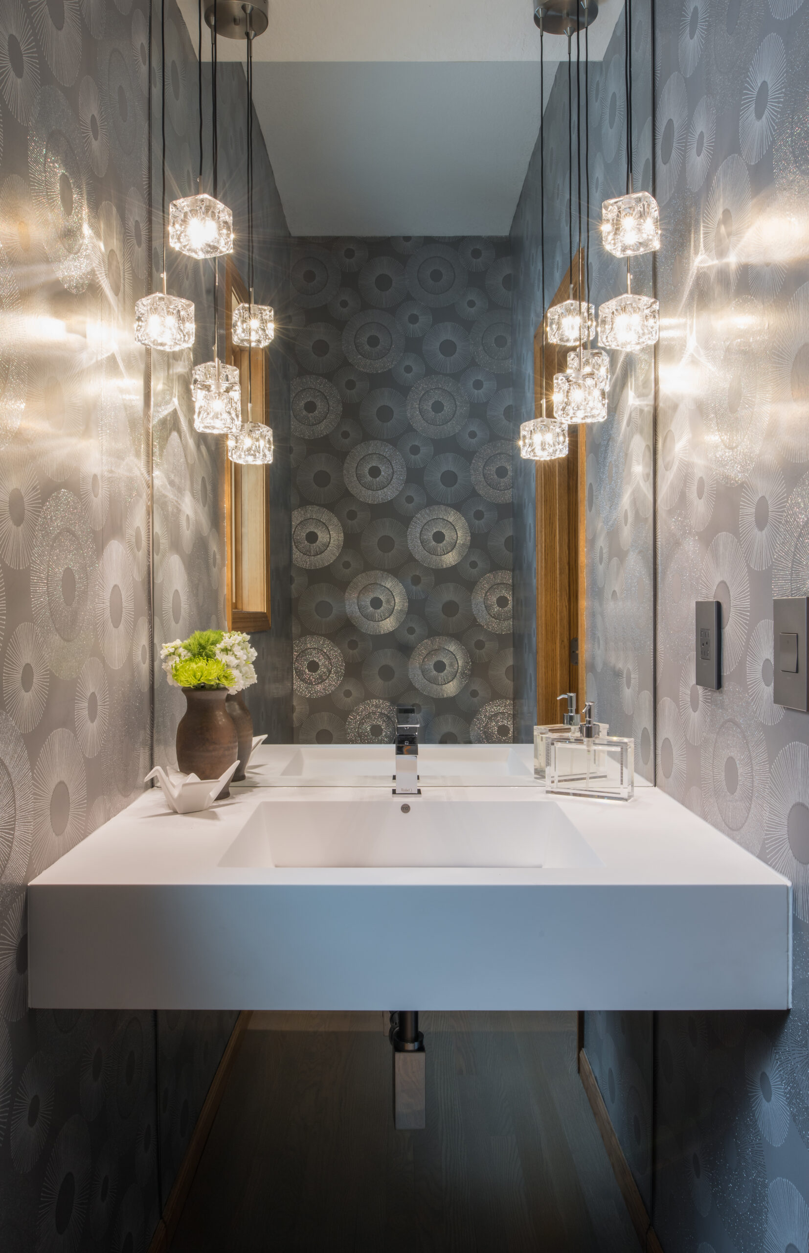 a single occupancy bathroom with a unique square chandelier 