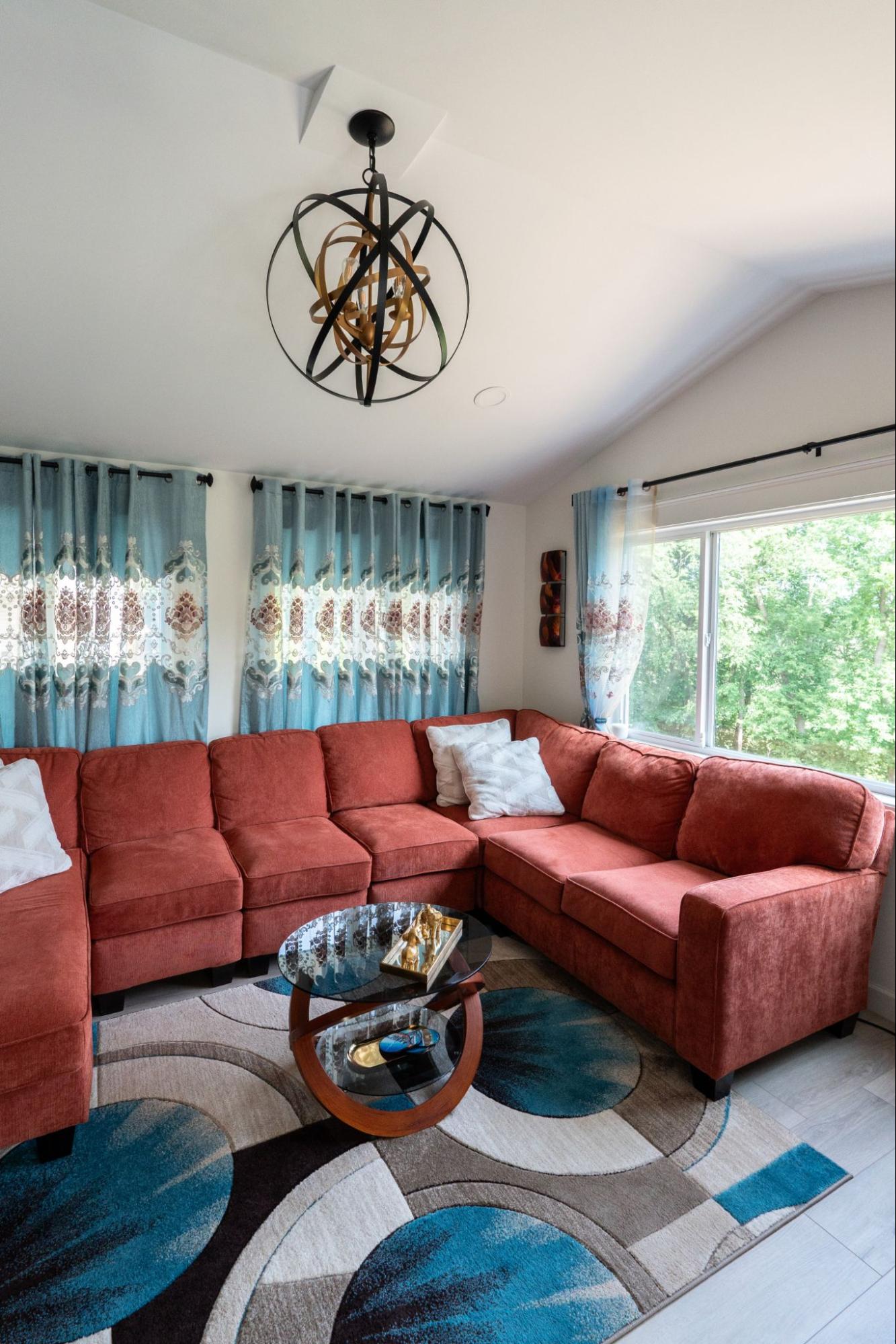 a living room with a rusty red sectional and blue decor