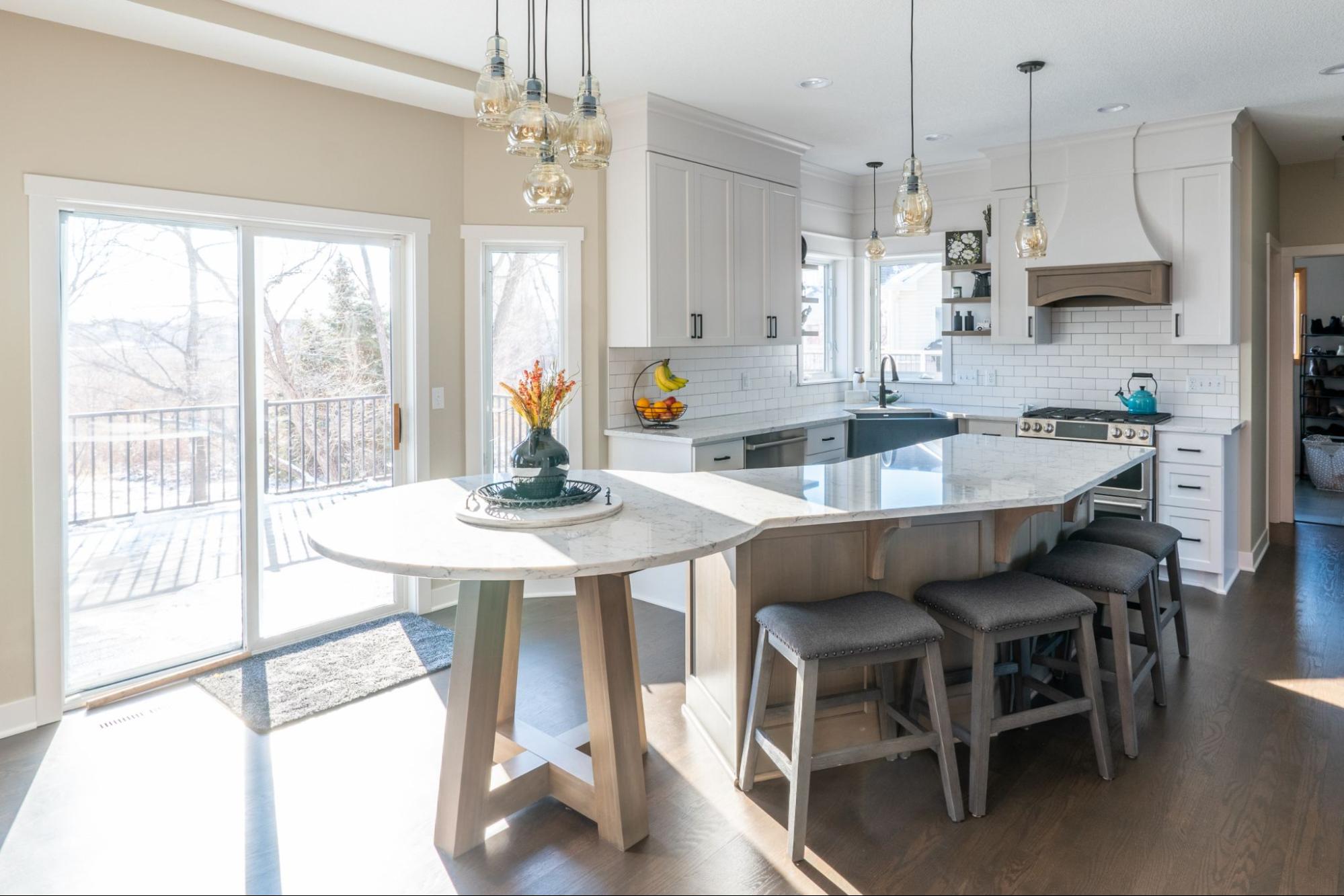 a kitchen with large windows and a sliding glass door to an exterior deck