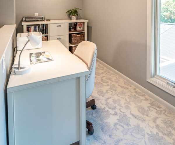 a small home office with a white desk and matching bookcase