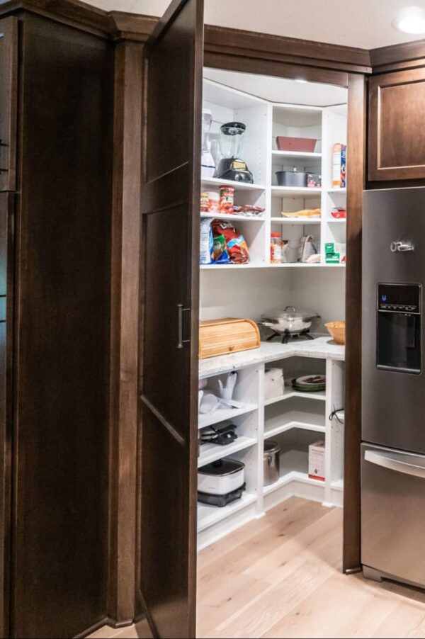 a view into a working pantry - a large pantry with additional shelving and a workstation