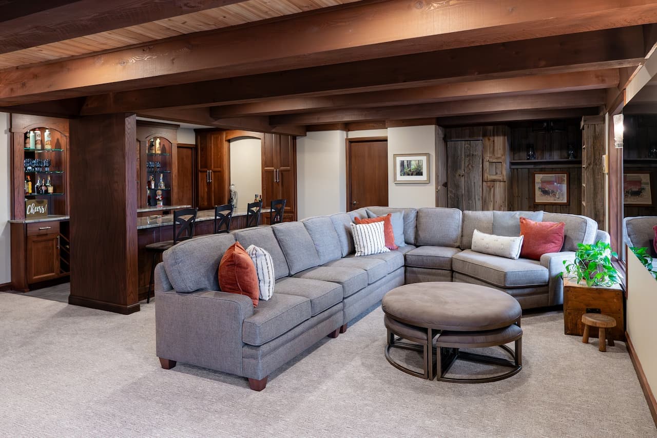 basement gathering area with grey couches and wooden walls