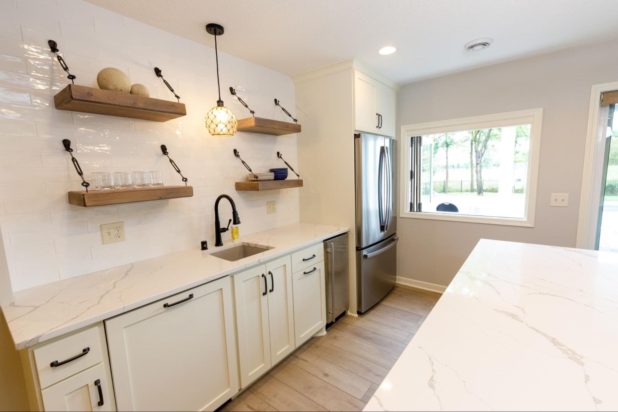 kitchenette in basement with open shelving and white countertops